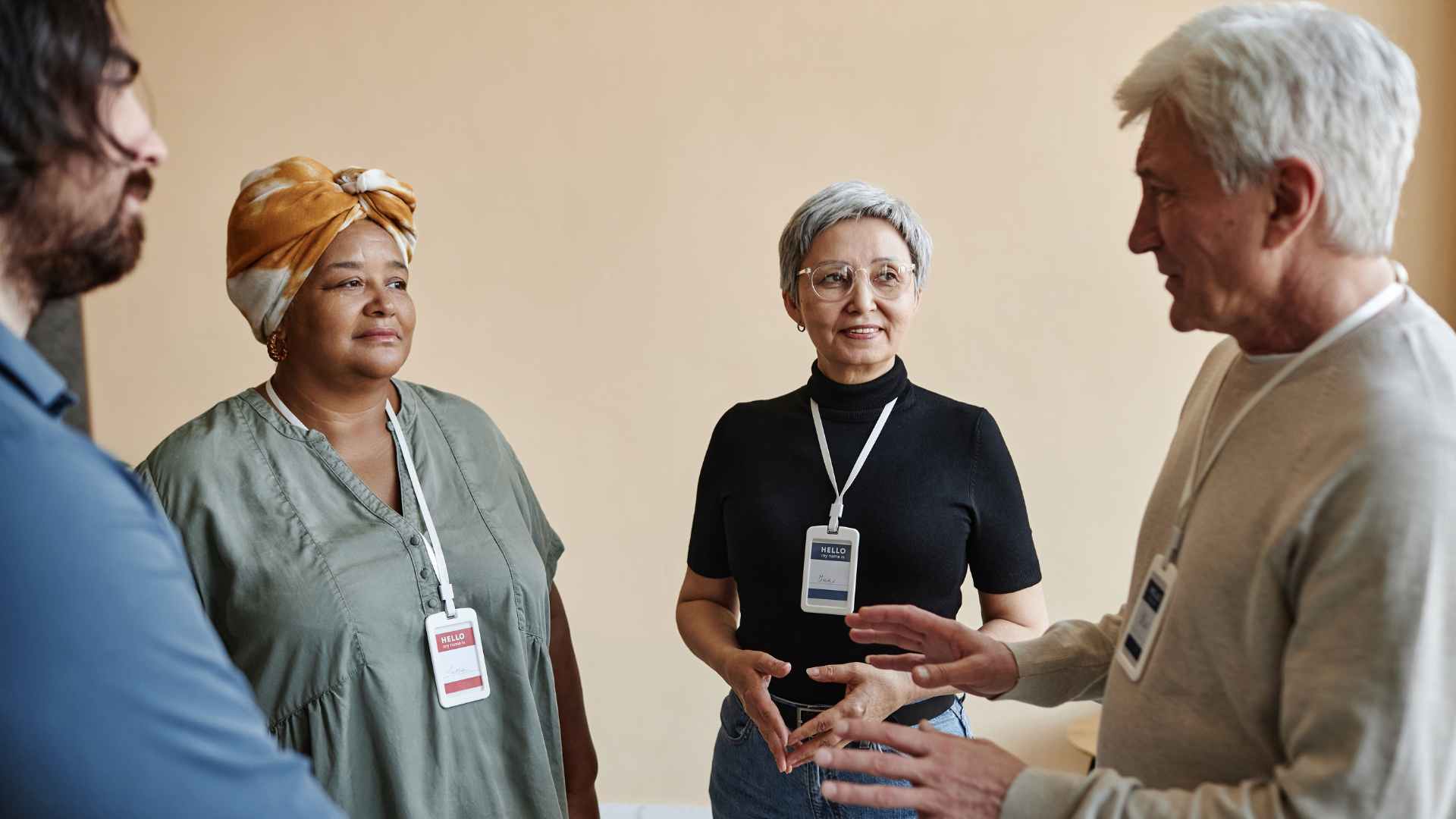 senior-man-talking-to-group-of-people-in-support-group